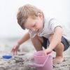 Scrunch - Flexibel Emmertje - pastel roze op het strand met jongetje